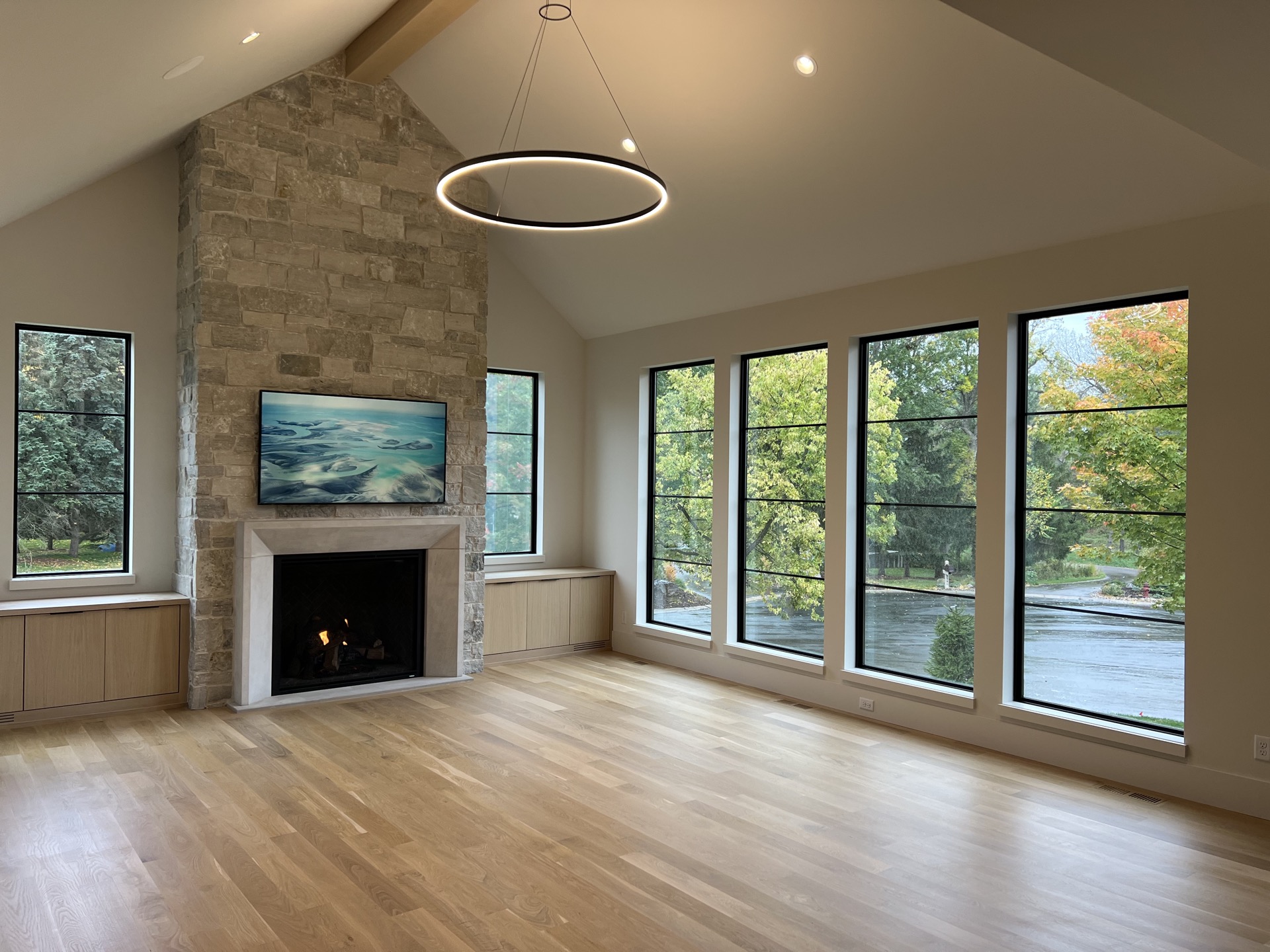 Vaulted living room with full-height stone fireplace and ring chandelier